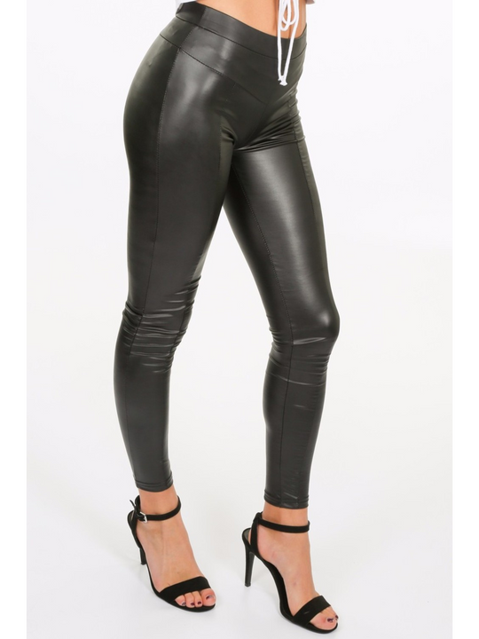 Model wears a wet look, leather looking leggings with panelling. This faux leather leggings has a bodycon slim fit.  Model stands to the side, the side of the panelled leggings can be seen.