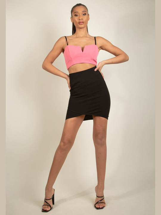 Full body view. Model wears a black bandeau style wrap dress, with a bodycon midi fit with an elasticated waist. The front of the bodycon skirt can be seen.