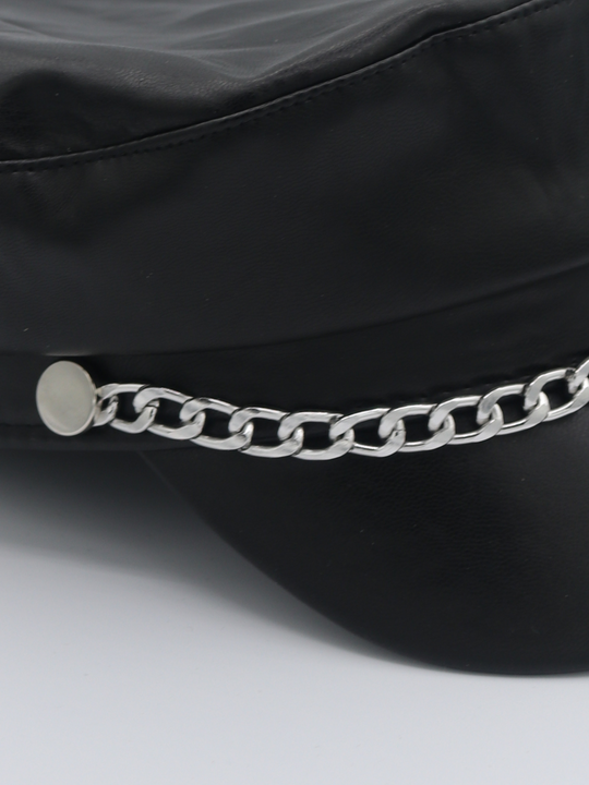 Close up of the pu leather hat. The picture shows a close up of the silver chain detailing at the front of the leather look PU baker boy hat. 