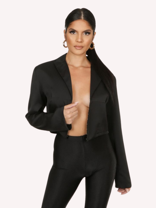 Model wears a black cropped shirt with a lapel, hook eye front closure and long sleeves that are wider at the cuffs.  Model stands with the shirt open, you can see the hook eye fastens .