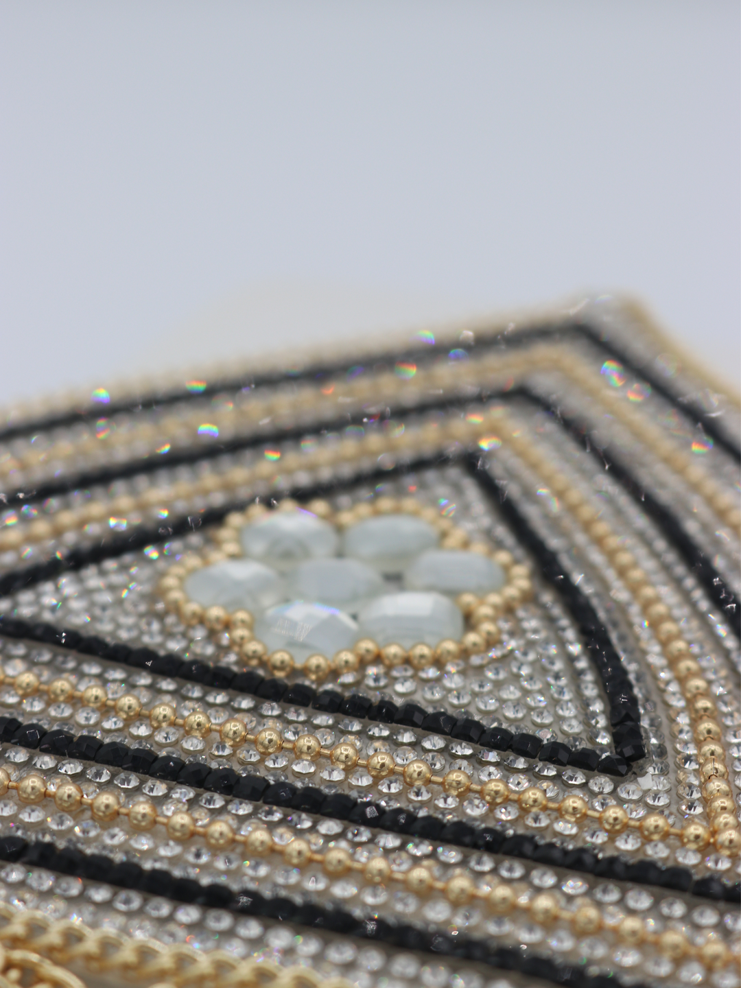 Close up of centre of the jeweled diamante bralette. The close up demonstrates the diamante and rhinestone design.  Some of the diamantes are glistening in the picture.