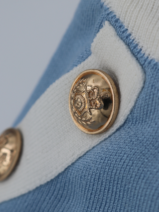 Close up of fine knit baby blue co ord set. A close up of the gold  military button detailing can be seen.