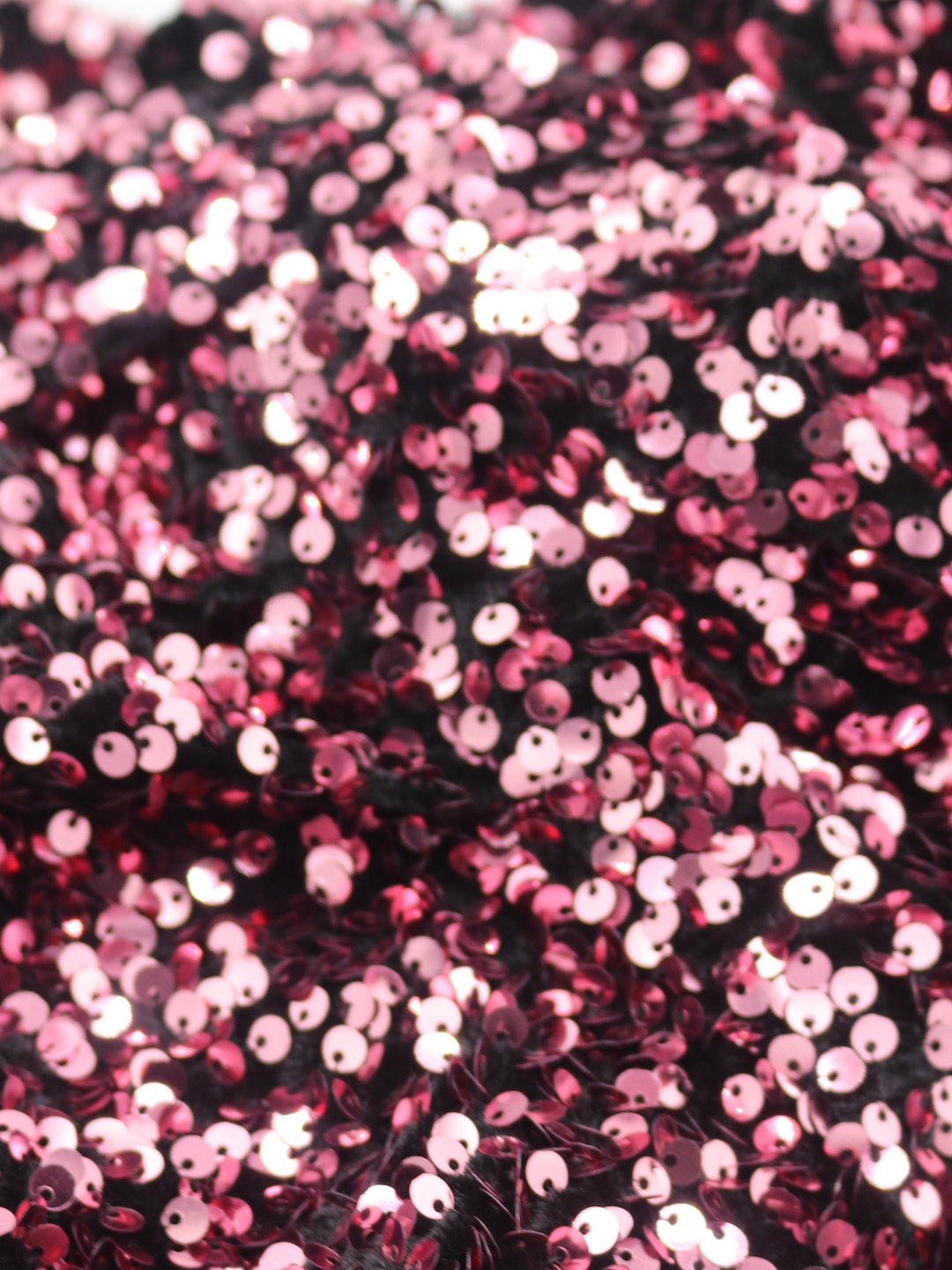 Close up of deluxe rose sequin mini dress with long sleeves. Close up of sequins, sown onto velvet dress.