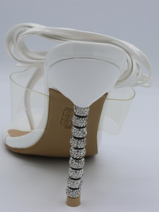 White strappy mules shoes with diamante stiletto heel. This is a statement shoe with a diamante heel.  The back of tghe shoe is visible. 
