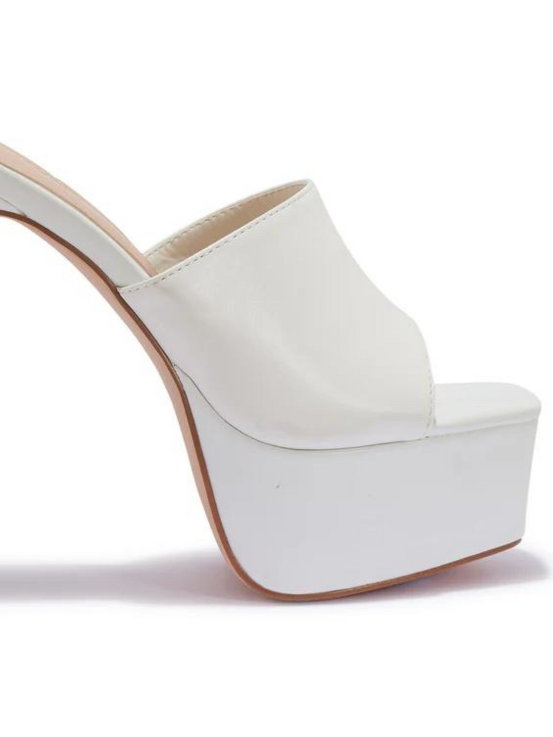 White heeled mules that have a thick platform base and stiletto shoes. The picture shows the thick platform and the shoes band. 