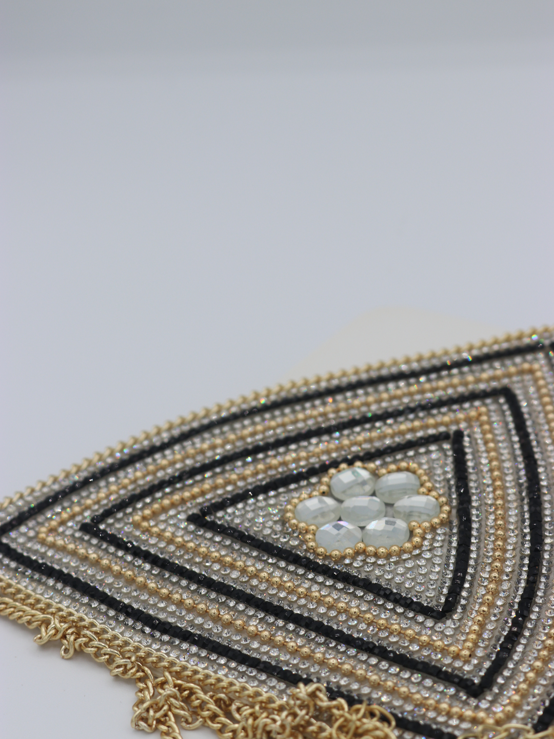 Close up of centre of the jeweled diamante bralette. The close up demonstrates the diamante and rhinestone design.  The gold chain fastening can be seen. 